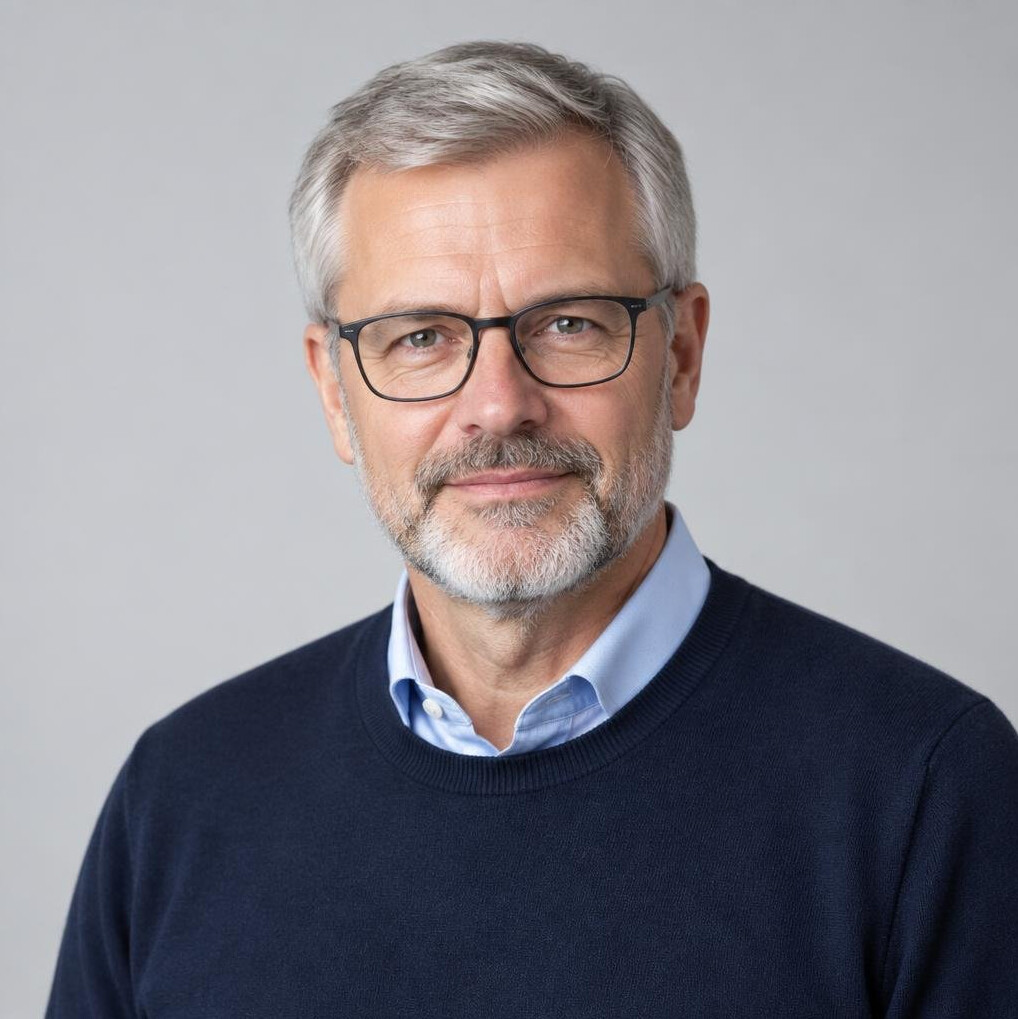 Studio portrait of a German man in his fifties with glasses and a grey beard