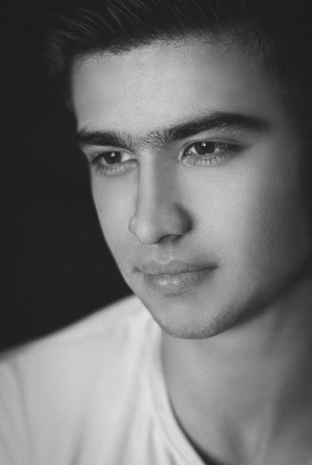 Studio portrait of a young man of Turkish-German descent with short dark hair in a casual shirt